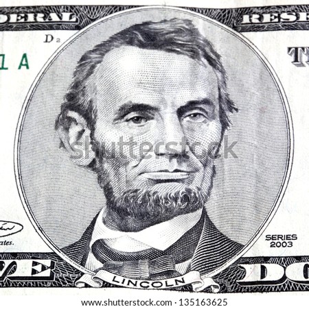 Portrait of Abraham Lincoln in front of the five dollar bill