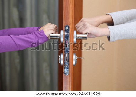 children hold hands on the door handle