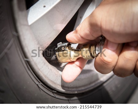 Checking tire pressure. Pumping air into auto wheel. Vehicle saf