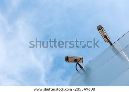 security camera on modern building with blue sky background