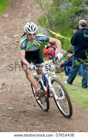 SANTIAGO, CHILE - SEPTEMBER 27: Rider number 52 climbs the circuit hill on Alpes Cup, mountain bike competition on September 27, 2009 in Santiago, Chile.