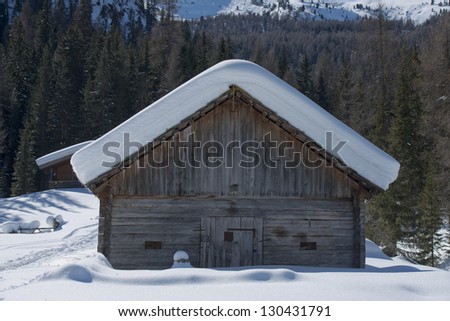 Old wood cabin house covered by snow
