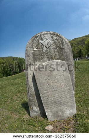 Old tomb stone in grave yard with masonic signs