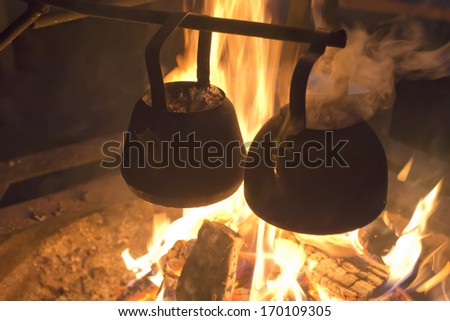cooking on the campfire inside a tent in winter time