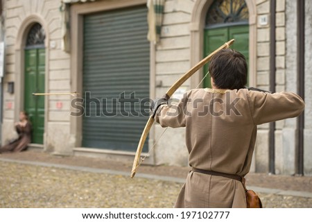 medieval archer while shooting a flying arrow