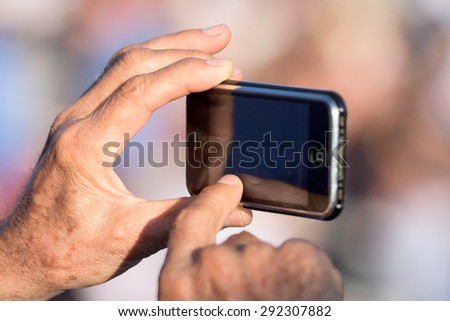old man hands taking picture with cellular phone
