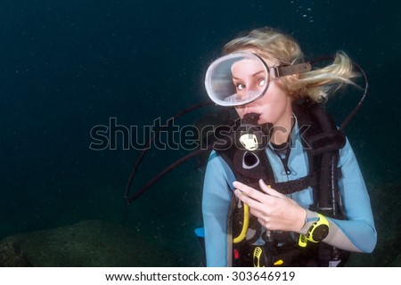 beautiful blonde girl diving in the deep blue sea