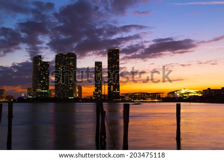 Dramatic sunset over Miami city downtown. Urban landscape and calm waters at sunset.