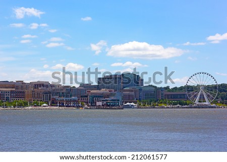 National Harbor photographed from Woodrow Wilson Bridge. National Harbor waterfront under blue cloudy sky in Maryland, USA