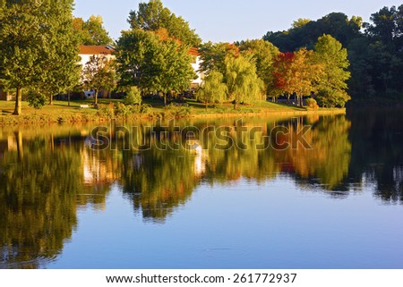 Autumn in a front lake community of Northern Virginia, US. Picturesque residential neighborhood with colorful trees in the fall.