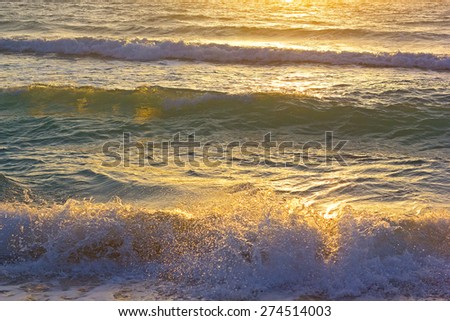 Ocean waves at sunrise in Miami Beach, Florida. Sun shines on ocean waves in the morning.