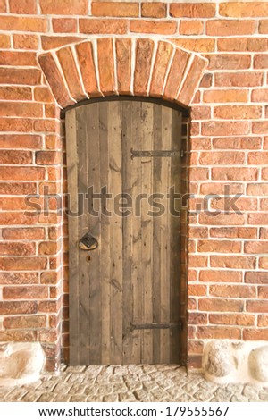 Wood arch door on red brick wall background