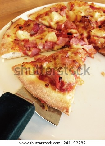 Ham and pineapple pizza on a cutting board detail