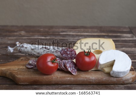 Mediterranean delicacy, salami and cheese with red tomato as food backgrounds.