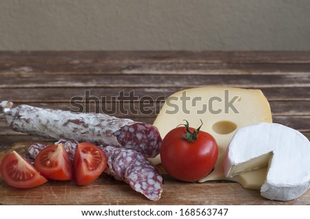 Mediterranean delicacy, salami and cheese with red tomato as food backgrounds.