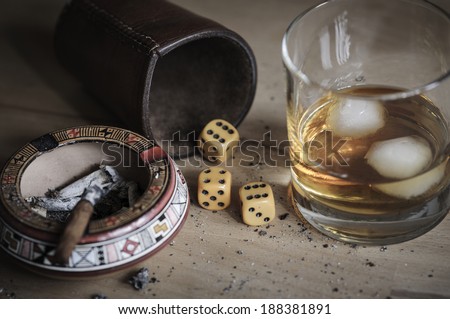 Dice game with cigar and alcoholic beverage.