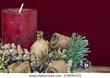 Background Christmas decoration, red candle in front of red velvet and copy space.