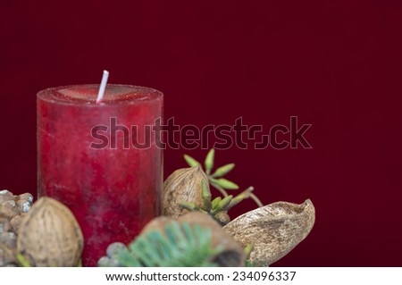 Background Christmas decoration, red candle in front of red velvet and copy space.
