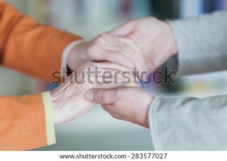 Young woman holding both hands a senior women.