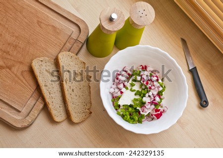 Organic breakfast on kitchen table - cottage cheese, bread, spices, spring onion, radish