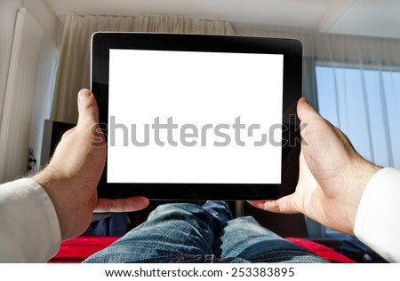 Man with tablet relaxing at home lying on bed - point of view photo