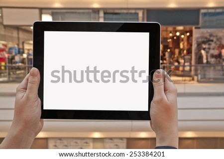 Tablet PC with empty screen in woman hand in a shopping center - shopping application display