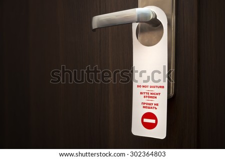 Do not disturb sign hanged on a closed door handle