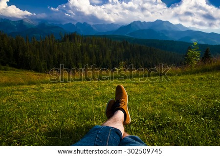 Man relaxing, enjoying mountain landscape on sunny day - point of view shot