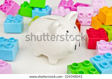 Piggy bank and colorful toy bricks - saving on toys