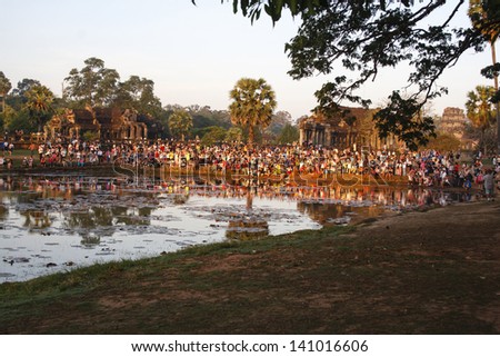 SIEM REAP, CAMBODIA - MAY 1: Sunrise at Angkor Wat in Cambodia - a crowd of tourists gathers to watch and photograph the sunrise on May 1, 2013.