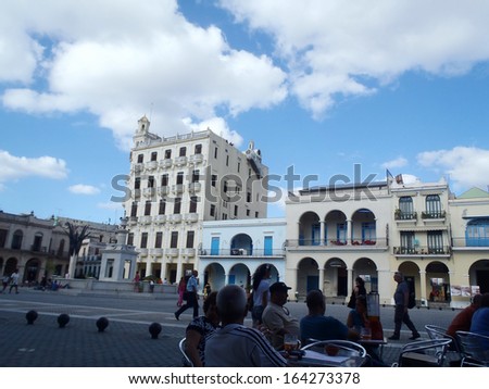 HAVANA, CUBA - APRIL 24: People resting at a bar in an Havana street lined with colonial style buildings and with piles of reconstruction rubble on April 24, 2012