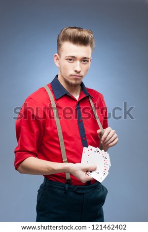 young caucasian man in red vintage shirt  holding playing cards