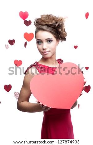 young cheerful caucasian brunette woman in red dress holding big red paper heart