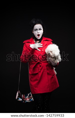 funny woman mime holding small fluffy dog and showing emotions