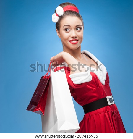 young cheerful retro girl in red vintage dress holding shopping bags