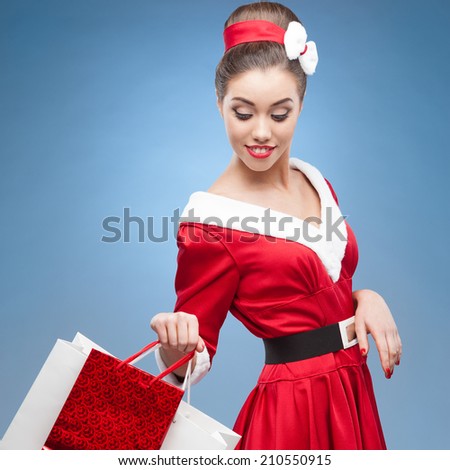 young cheerful retro girl in red vintage dress holding shopping bags