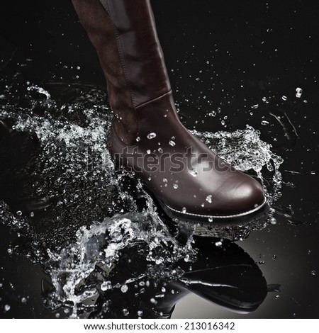 brown leather female boot splashing water