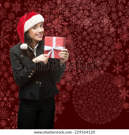 business woman in santa hat holding gift over red snowflakes background