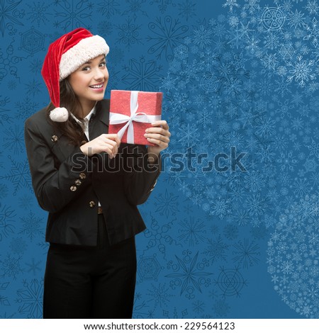 business woman in santa hat holding gift over blue snowflakes background