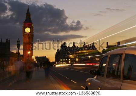 As the world passes by a taxi cab stops on Westminster Bridge next to the Houses of Parliament in London