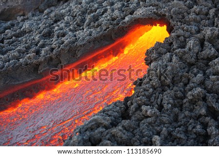 Lava flowing from small tunnel on flank of Pacaya volcano, Guatemala