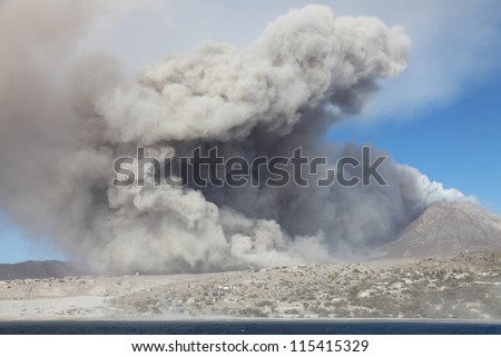 Ash cloud rising from pyroclastic flow from Soufriere Hills volcano approaching abandoned town of Plymouth, Montserrat