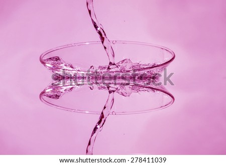 Water splashing from glass isolated on white background. Manipulated image