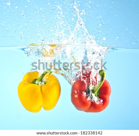 red and yellow pepper splashed into water