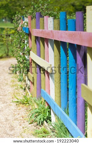 Colorful wooden fence posts  lead you along garden path.