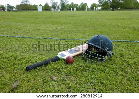 Equipment at cricket match on English village green.