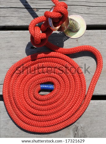 Red rope coiled up on a wooden dock