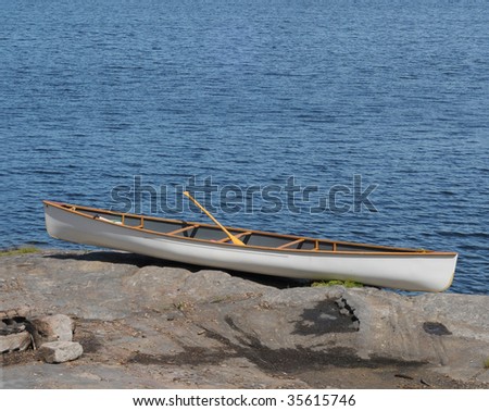 White canoe on rocky shore