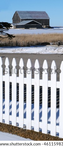 White picket fence and a barn