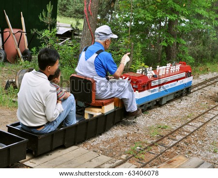 WHITCHURCH-STOUFVILLE, ONTARIO - June 5: Train engineer with a father and a son on a miniature model train during the Open Doors Live Steamers event on June 5, 2010 at Stoufville, Ontario, Canada